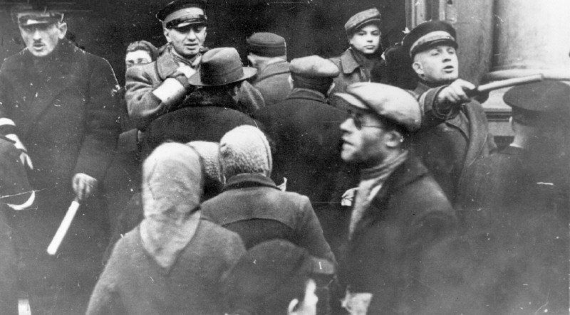 Jewish policemen, equipped with nightsticks, maintaining crowd control at the Judenrat building in the Warsaw ghetto.